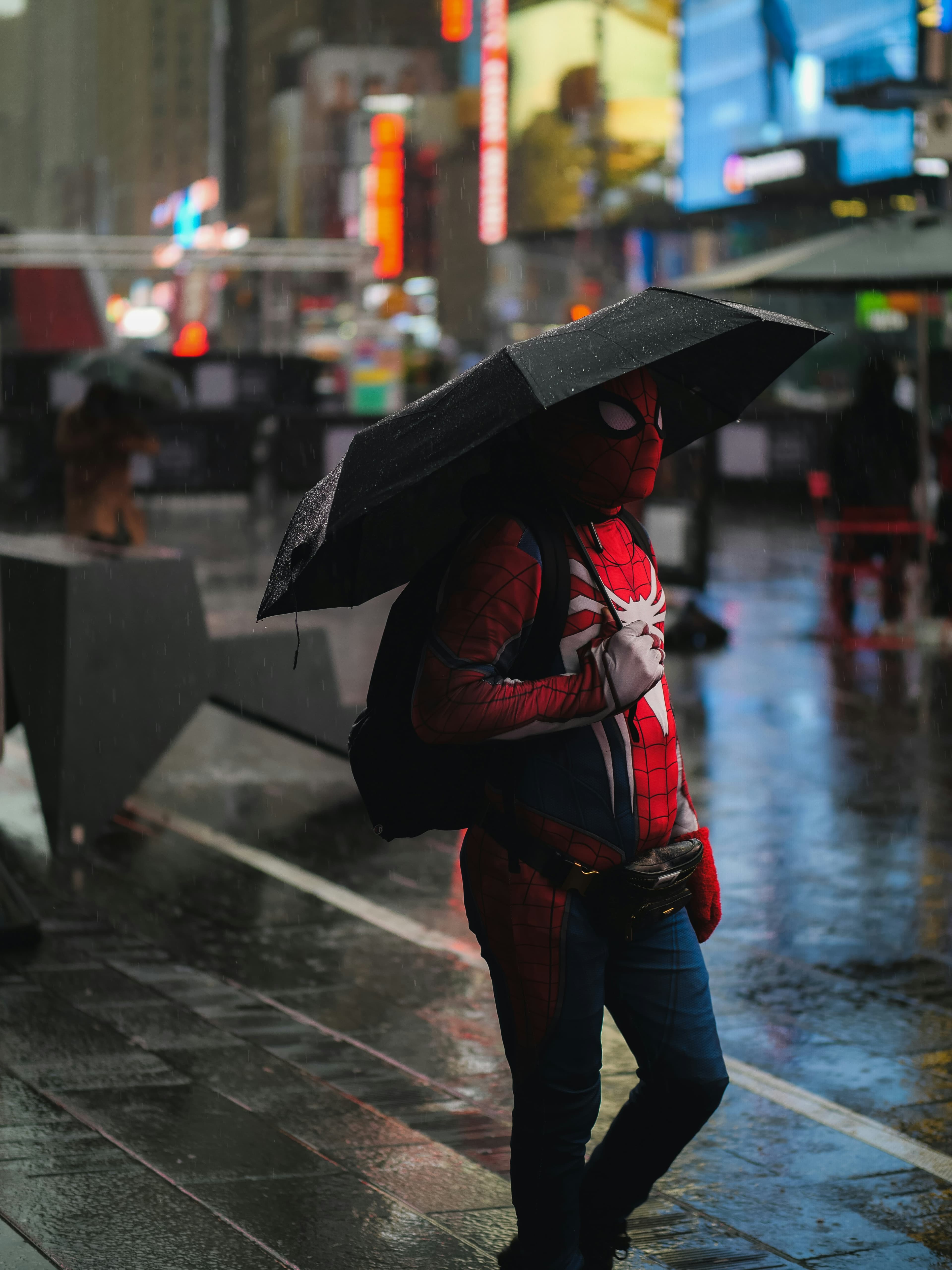 Person with a spiderman costume under the rain